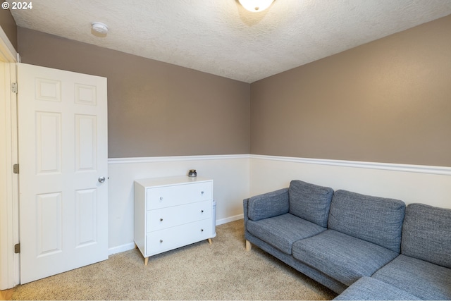 interior space featuring a textured ceiling, baseboards, and carpet flooring