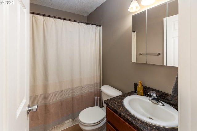 full bathroom featuring curtained shower, toilet, a textured ceiling, and vanity