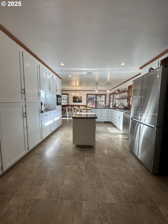 kitchen featuring ceiling fan, a center island, appliances with stainless steel finishes, white cabinets, and ornamental molding