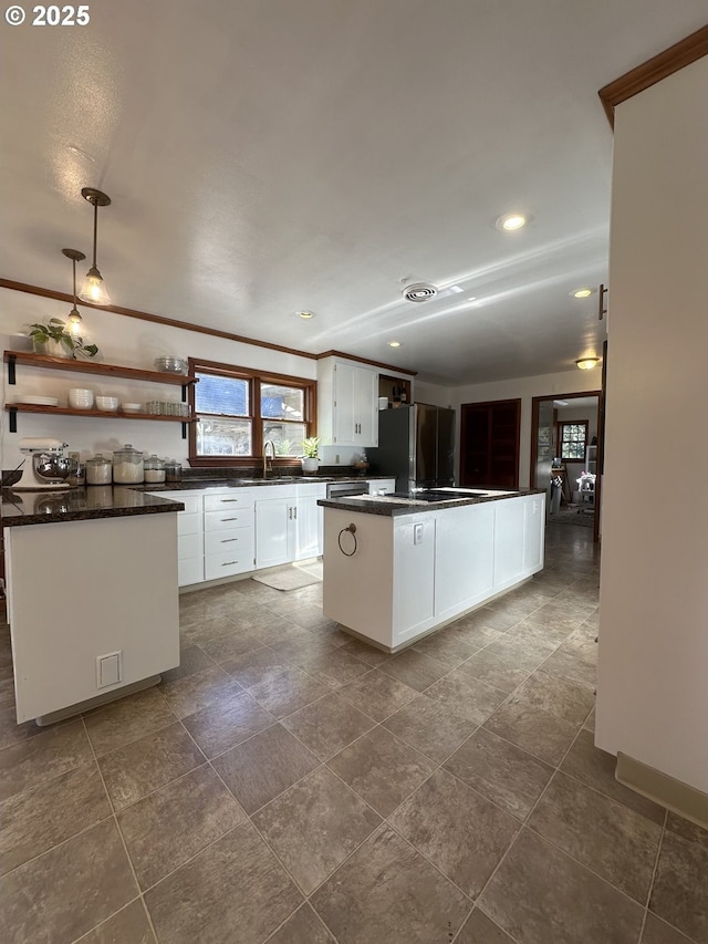 kitchen featuring stainless steel fridge, sink, a center island, white cabinetry, and hanging light fixtures