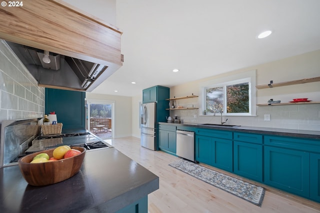 kitchen with blue cabinetry, plenty of natural light, light hardwood / wood-style flooring, and appliances with stainless steel finishes