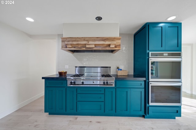 kitchen with backsplash, stainless steel appliances, blue cabinets, and light hardwood / wood-style floors