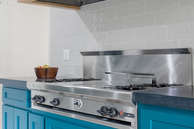 interior details featuring tasteful backsplash, blue cabinetry, and stainless steel gas stovetop