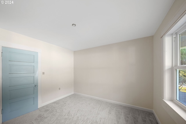 unfurnished room with carpet flooring and a wealth of natural light