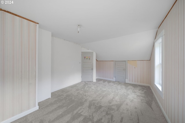 interior space featuring light colored carpet and vaulted ceiling