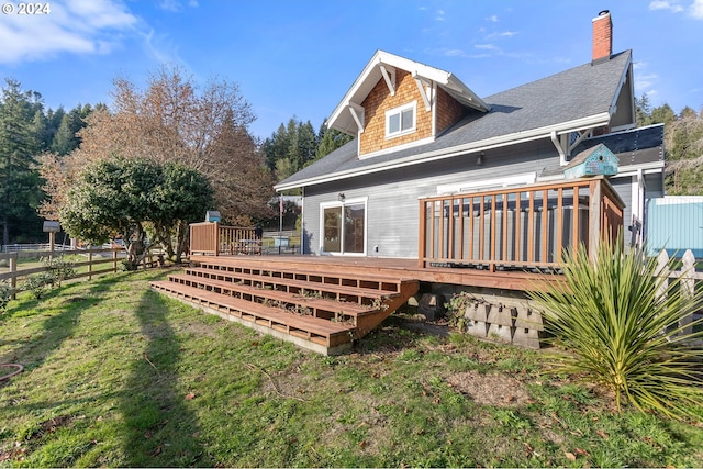 back of house featuring a wooden deck and a yard