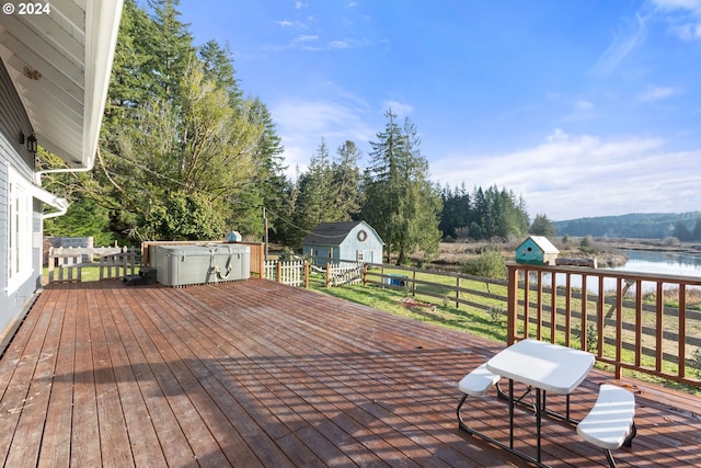 wooden deck featuring a water view and a storage unit