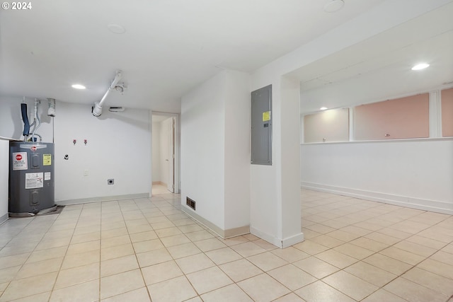 basement featuring electric panel, electric water heater, and light tile patterned flooring