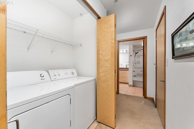 clothes washing area featuring light carpet and washer and clothes dryer