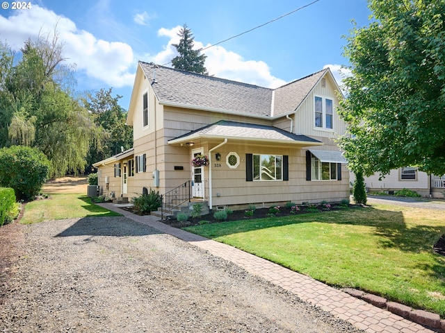 view of front of property featuring cooling unit and a front lawn