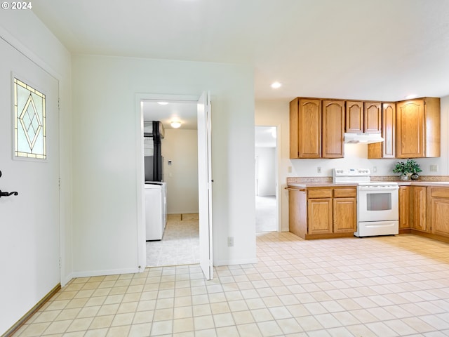 kitchen featuring washer / dryer and white range with electric cooktop