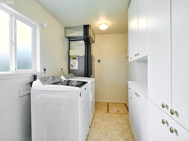 laundry area featuring light tile patterned flooring, washing machine and dryer, and cabinets