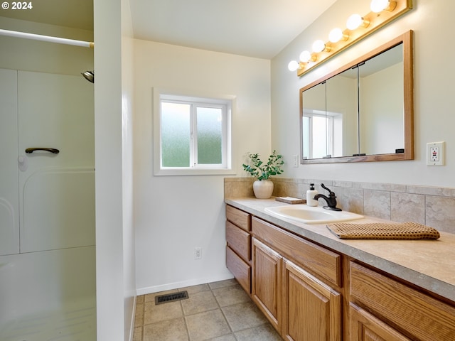 bathroom with vanity, tile patterned floors, and walk in shower