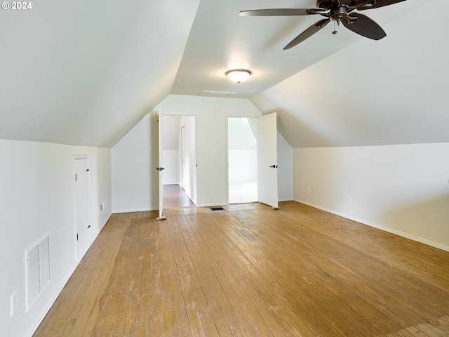 additional living space with vaulted ceiling, light hardwood / wood-style flooring, and ceiling fan