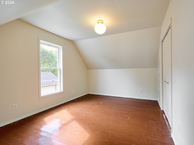 bonus room with vaulted ceiling and dark hardwood / wood-style flooring