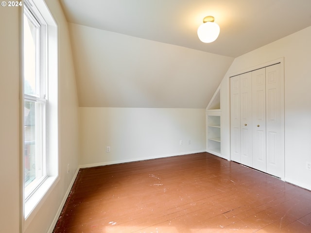 additional living space featuring vaulted ceiling and dark hardwood / wood-style flooring