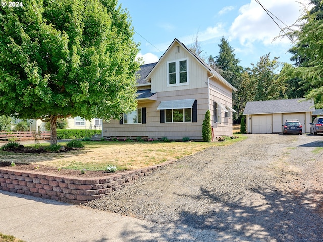 view of front of property with a front lawn, an outbuilding, and a garage