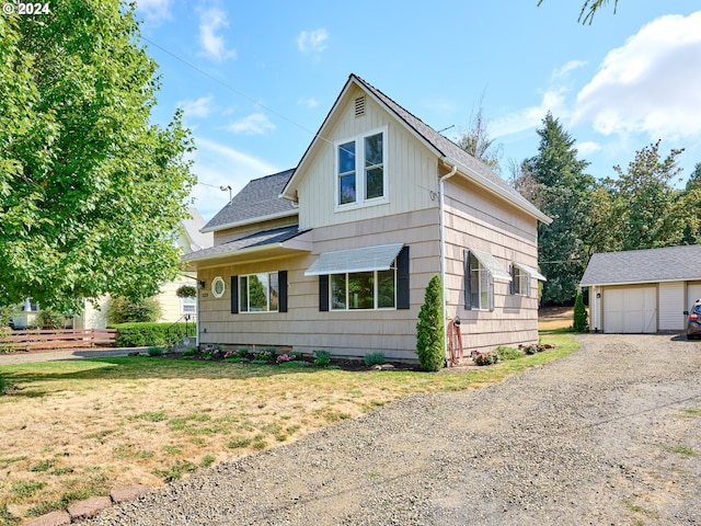 view of front of home featuring a front lawn, an outbuilding, and a garage