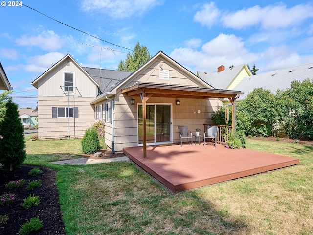 back of property with a wooden deck and a lawn