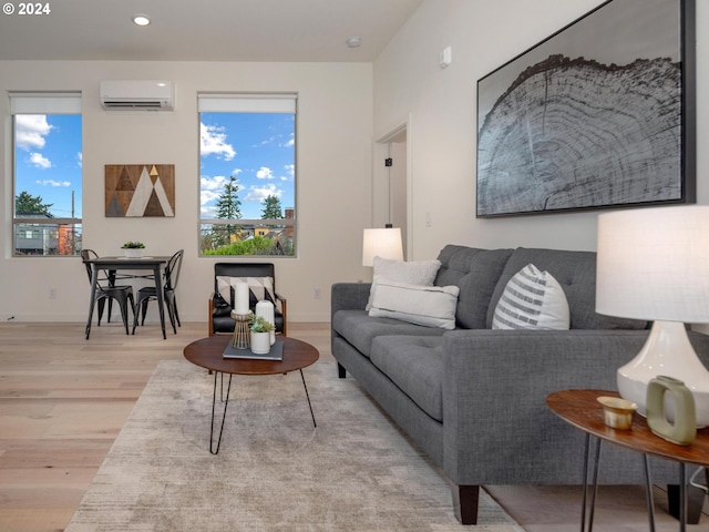 living room featuring a wall mounted air conditioner and light hardwood / wood-style flooring