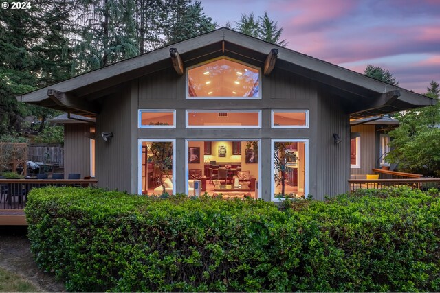 back house at dusk with a deck