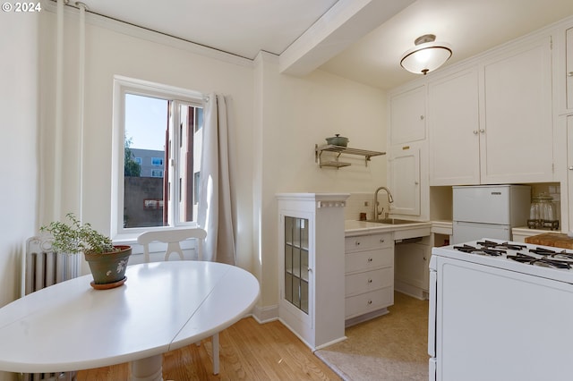 kitchen featuring white cabinetry, range, sink, light hardwood / wood-style floors, and refrigerator