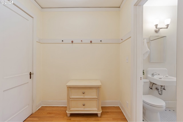 bathroom featuring sink, wood-type flooring, ornamental molding, and toilet