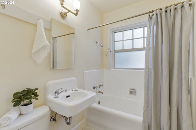 full bathroom featuring shower / tub combo with curtain, toilet, and sink