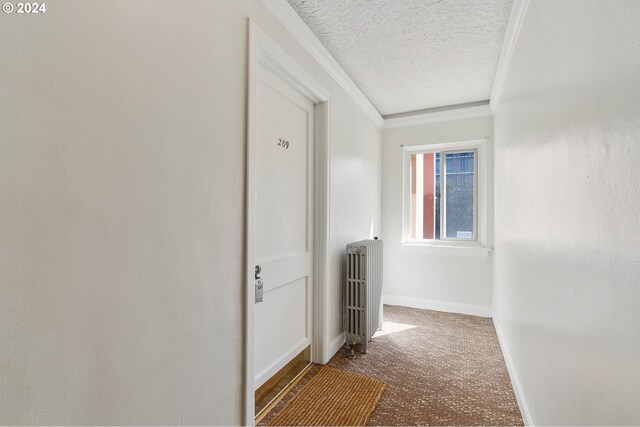 hall featuring ornamental molding, carpet, radiator, and a textured ceiling