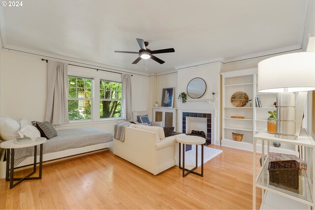 living room featuring hardwood / wood-style flooring, ceiling fan, and a fireplace