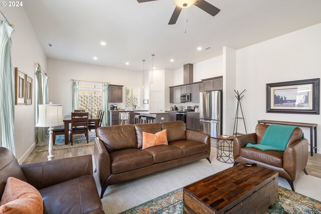 living room featuring ceiling fan and light wood-type flooring