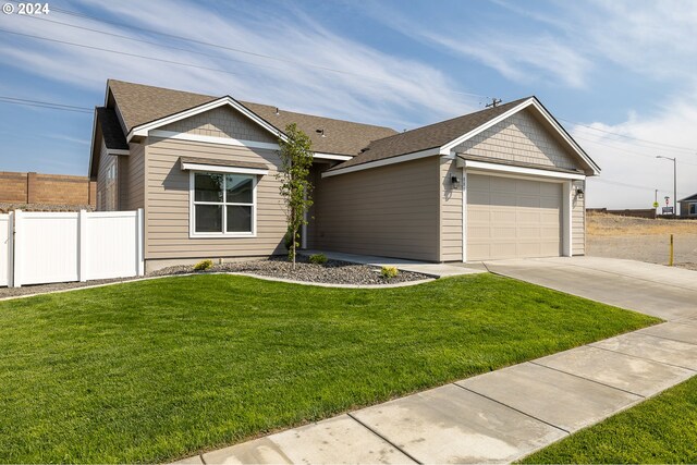 single story home with a front yard and a garage