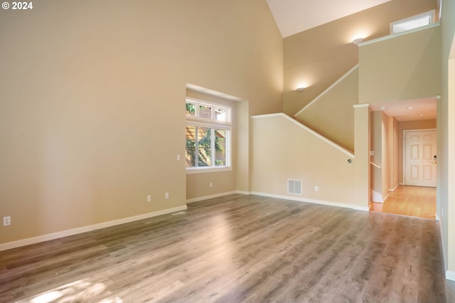 spare room with a towering ceiling and hardwood / wood-style flooring