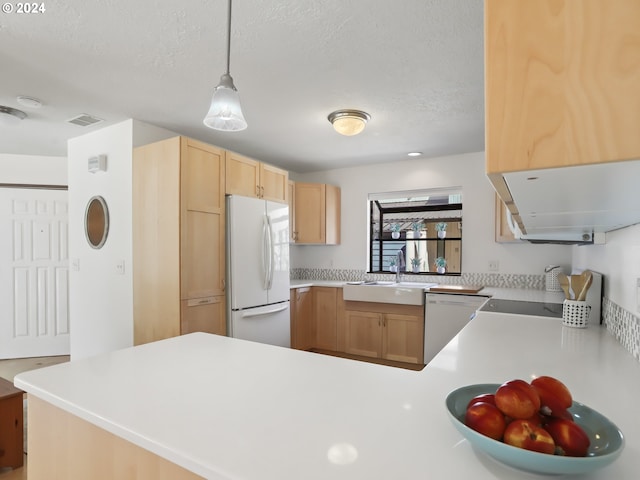 kitchen featuring dishwasher, light brown cabinets, hanging light fixtures, kitchen peninsula, and white fridge