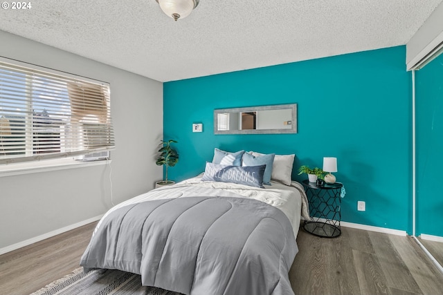 bedroom featuring a textured ceiling and wood-type flooring