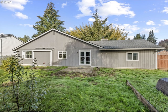 rear view of house with a patio and a lawn