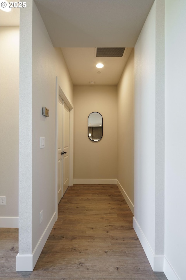 hallway with hardwood / wood-style flooring