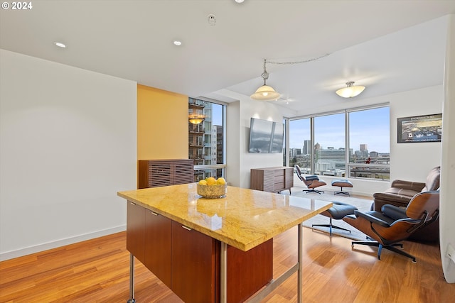 kitchen featuring decorative light fixtures, a kitchen island, and light hardwood / wood-style floors