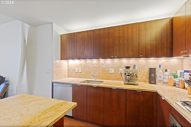 kitchen featuring sink, decorative backsplash, dark hardwood / wood-style floors, light stone countertops, and stainless steel appliances