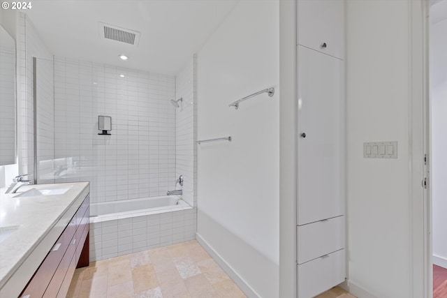 bathroom featuring vanity and tiled shower / bath