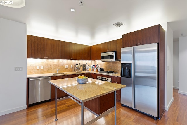 kitchen with a center island, a kitchen bar, light wood-type flooring, and stainless steel appliances