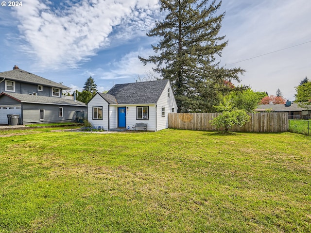 rear view of house featuring a yard