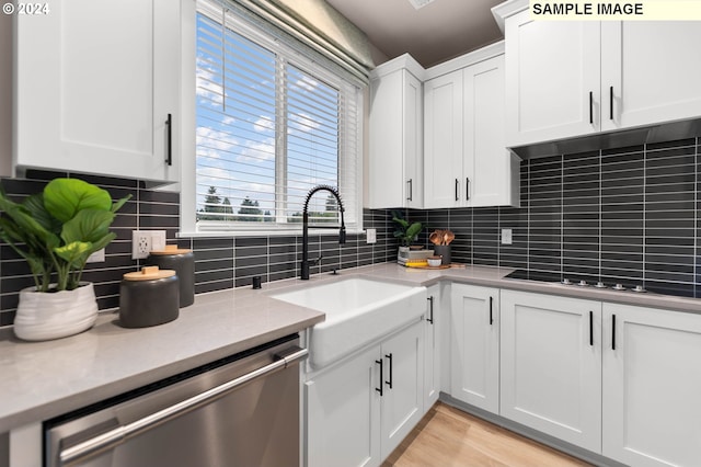 kitchen featuring backsplash, white cabinetry, dishwasher, and sink