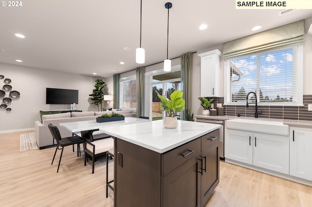 kitchen featuring tasteful backsplash, white cabinets, and pendant lighting