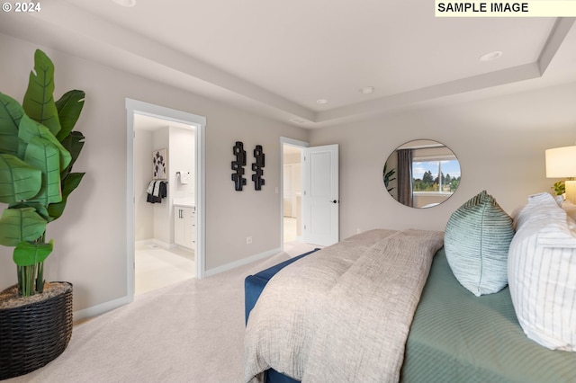 bedroom featuring carpet flooring, ensuite bathroom, and a tray ceiling