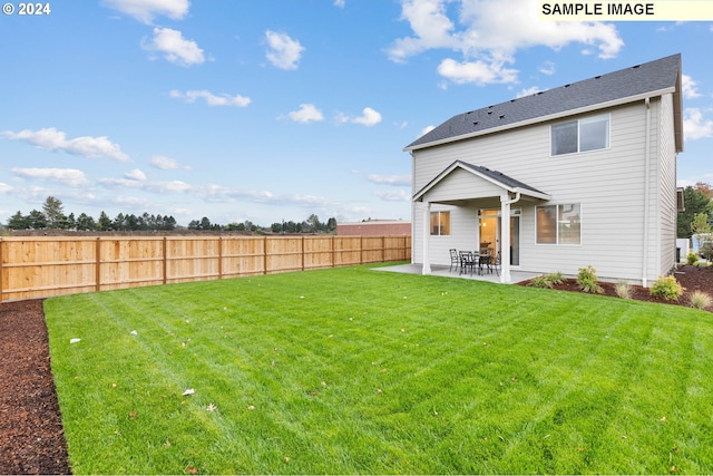 back of house featuring a lawn and a patio