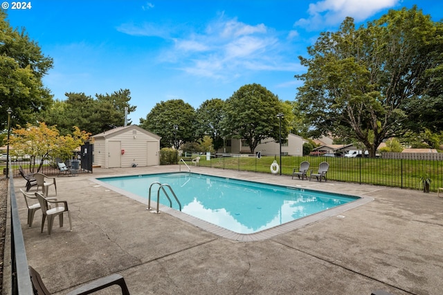 view of pool featuring a patio area and a shed