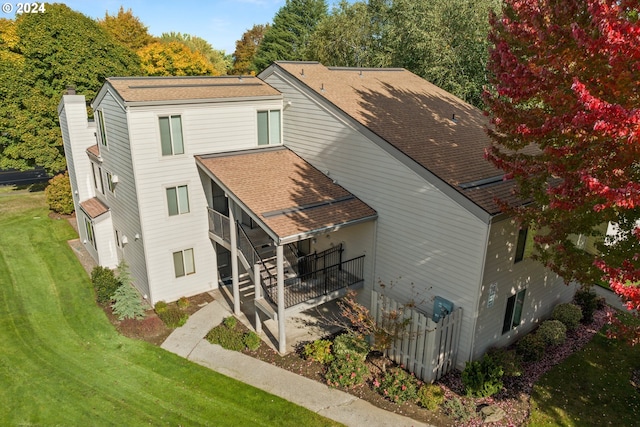 back of house with a yard and a sunroom