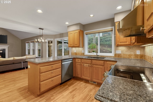 kitchen featuring kitchen peninsula, extractor fan, dishwasher, decorative light fixtures, and sink