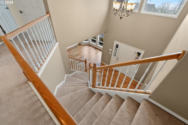 stairway with carpet flooring and a chandelier